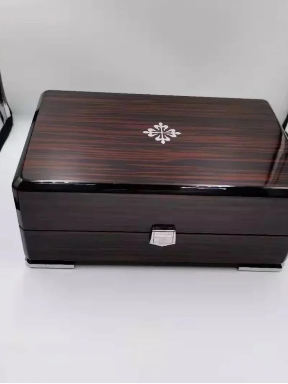 Patek Philippe Brown Wood-Grain Watch Case with Silver Emblem